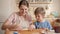 Young mother teaching her little son baking sweet roll with jam filling. Children cooking with parents, little chef