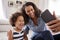 Young mother and toddler daughter taking selfie at home