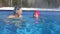 Young mother together daughter swimming in thermal pool on winter resort