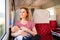 Young mother travelling with baby by train.
