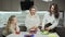 Young mother and two her daughters cooks salad at kitchen. Woman and daughter clean carrot and potato.