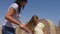 Young mother using brush for combing long hair to daughter outdoor