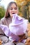 Young mother on a walk with a baby in the autumn park. Mom smiles and looks at the child with tenderness