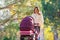 Young mother walks in the autumn park with a stroller