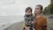 A young mother walks with her son on the shores of the picturesque Lake Ontario