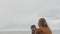 A young mother walks with her son on the shores of the picturesque Lake Ontario