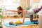 Young mother working out at home on a mat with baby. Interior of a nursery room. Woman practicing yoga together with child