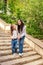 A young mother with a young daughter comes down the stairs. A woman holds a girl`s hand and talks to her