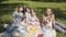 Young mothers with children sitting in a Park on a picnic.