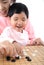 Young mothers teach their children to play go