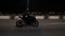 A young motorcyclist rides a motorcycle on a night road.