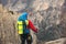 Young mountaineer standing with backpack on top of a mountain