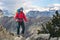 Young mountaineer standing with backpack on top of a mountain