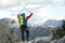 Young mountaineers standing with backpack on top of a mountain