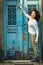 A young multicultural asian woman stands at the doors of a house on the streets of Porto