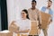 young multiethnic coworkers holding cardboard boxes while relocating