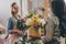 Young multiethnic florists in aprons working with flowers in flower shop