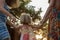 Young mum with blonde daughter girls smiling doing ring around the rosie . Warm sunset light. Family summer travel