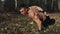 Young muscular athletic man exercising doing push-ups on one arm in the forest. Strong caucasian guy with naked torso