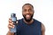 Young muscular build man hold bottle water after running, attractive athlete resting after workout outdoors, fitness and