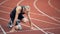 Young muscular concentrated athlete at the start of the treadmill at the stadium