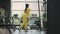 Young muscular hispanic woman doing Lunges exercise with dumbbells in the gym In yellow sportswear. Female athlete