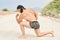 Young muscular man exercising on the beach, young muscular man doing bodibuilding exercises on the beach, athletic young man posin