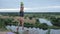 A young muscular man with a naked torso makes does a handstand and then on one hand standing on a bench by the river