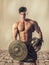 Young muscular man posing in gladiator costume