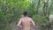 Young muscular man running along trail at early autumn forest. Unrecognizable sportsman sprinting along path at nature