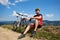 Young muscular sportsman biker in professional sportswear sitting near his bike