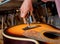 Young musician changing strings on a classical guitar in a guitar shop