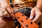 Young musician changing strings on a classical guitar in a guitar shop