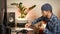 Young musician composer with acoustic guitar composing music or song, making notes in notebook. Creative guitarist playing guitar
