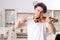 Young musician man practicing playing violin at home