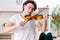 Young musician man practicing playing violin at home