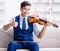 Young musician man practicing playing violin at home