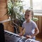 Young musician playing classic digital piano at home during online class at home, self-isolation