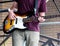 Young musician playing guitar at the street during music fest