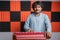 Young musician playing Indian music instrument Harmonium in studio.