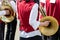 Young musicians of brass band playing french horns during street