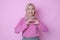 Young Muslim Asian woman showing romantic shapes heart gesture expresses tender feelings wears casual muslim clothes poses against