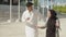 Young muslim couple performing traditional dance on sunny day.