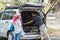 Young muslim family , transport, leisure, road trip and people concept - happy man, woman and little girl getting ready for