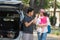 Young muslim family , transport, leisure, road trip and people concept - happy man, woman and little girl playing with doll beside