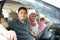 Young muslim family , transport, leisure, road trip and people concept - happy man, woman and little girl traveling in a car looki