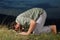 Young muslim man is praying on meadow sunset time