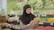 Young Muslim woman examining bunch of bananas in grocery. Portrait of beautiful lady choosing fresh delicious organic