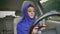 Young muslim woman in hijab sitting behind self-driving steering wheel of autonomous autopilot driverless car and typing