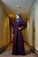 Young Muslim woman in trendy Islamic clothing, standing in the corridor of the hotel